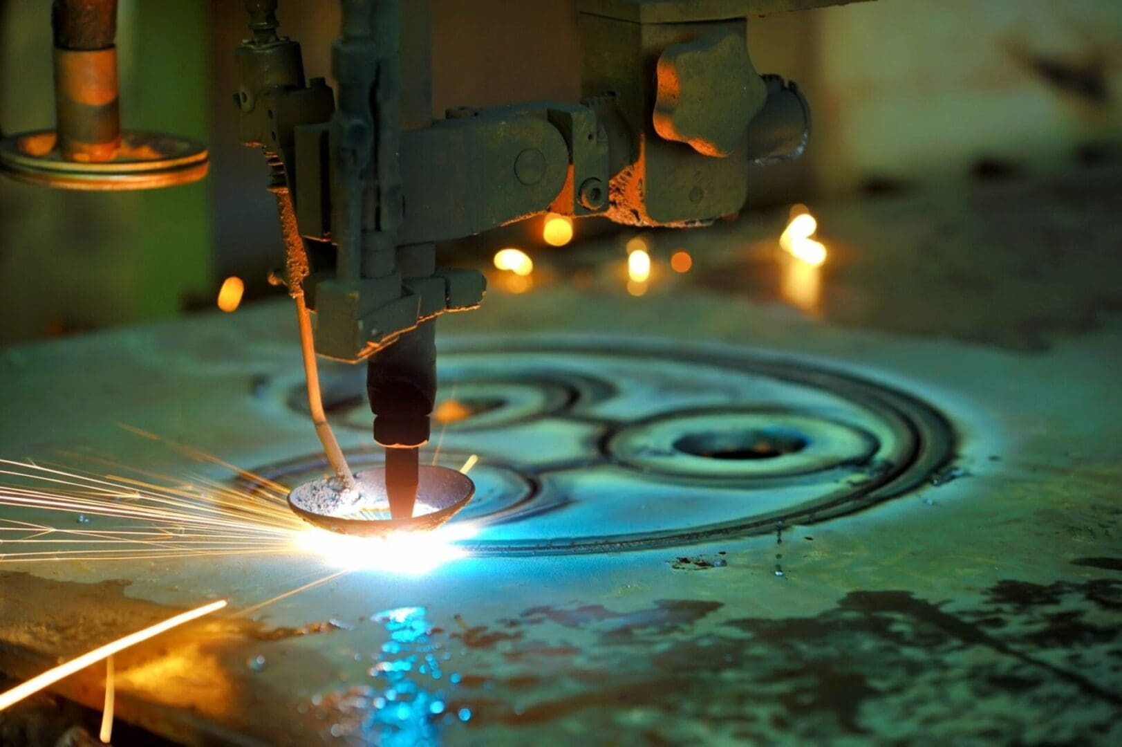 A machine is cutting metal with blue light.