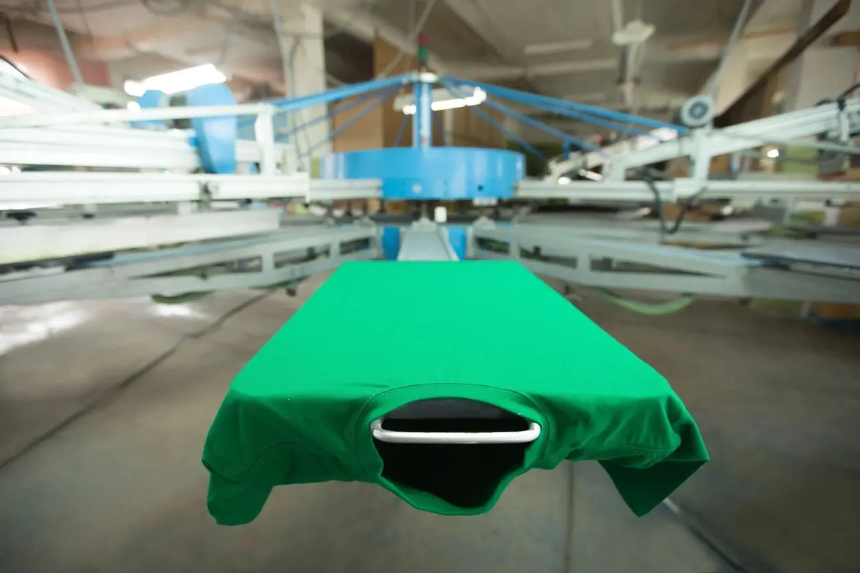 A green shirt is being made on the machine.